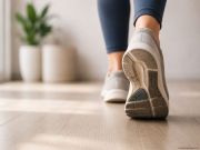 Una persona cammina in un ambiente luminoso indossando sneakers chiare. L’immagine mette in evidenza la suola della scarpa e il movimento del passo, richiamando il tema dell’appoggio del piede, del cammino e delle abitudini quotidiane. Atmosfera semplice, naturale e accogliente.